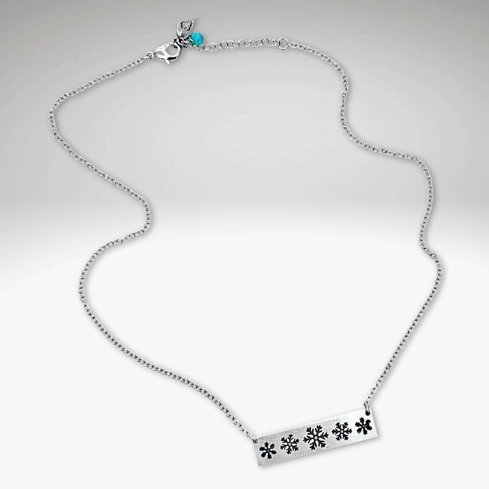 Snowfall Necklace showcasing elegant snowflake bar design on a silver chain, perfect for winter lovers.