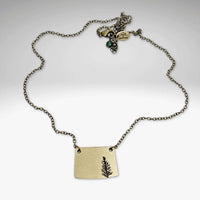 Spruce Necklace featuring a fern pendant on an antique brass chain, highlighting nature's elegance.