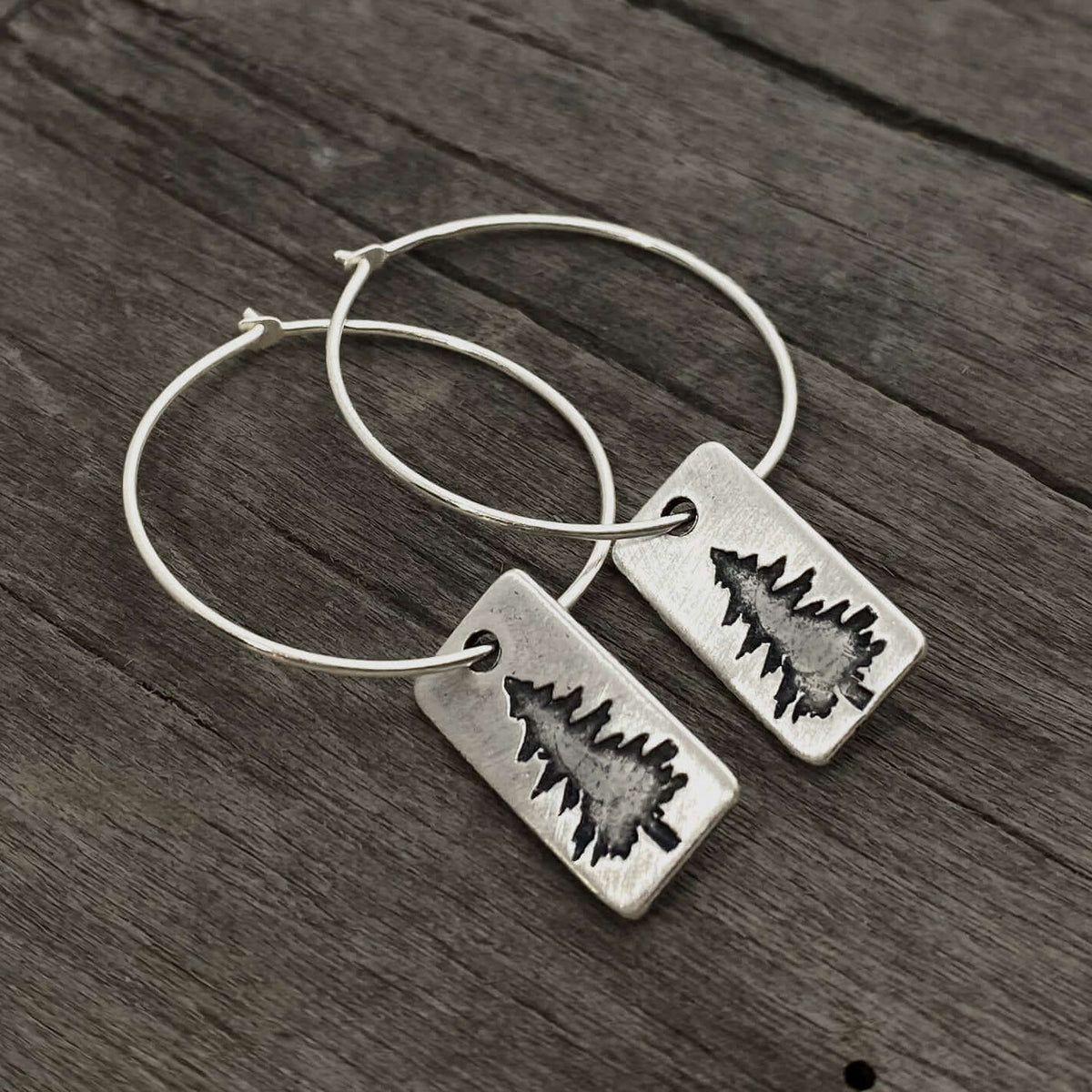 Spruce Tree Hoop Earrings featuring a small spruce tree design on sterling silver hoops.