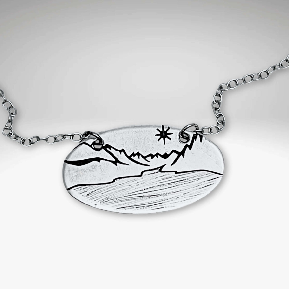 St. Mary Lake in Glacier Necklace featuring intricate mountain and lake design on a silver cable chain.