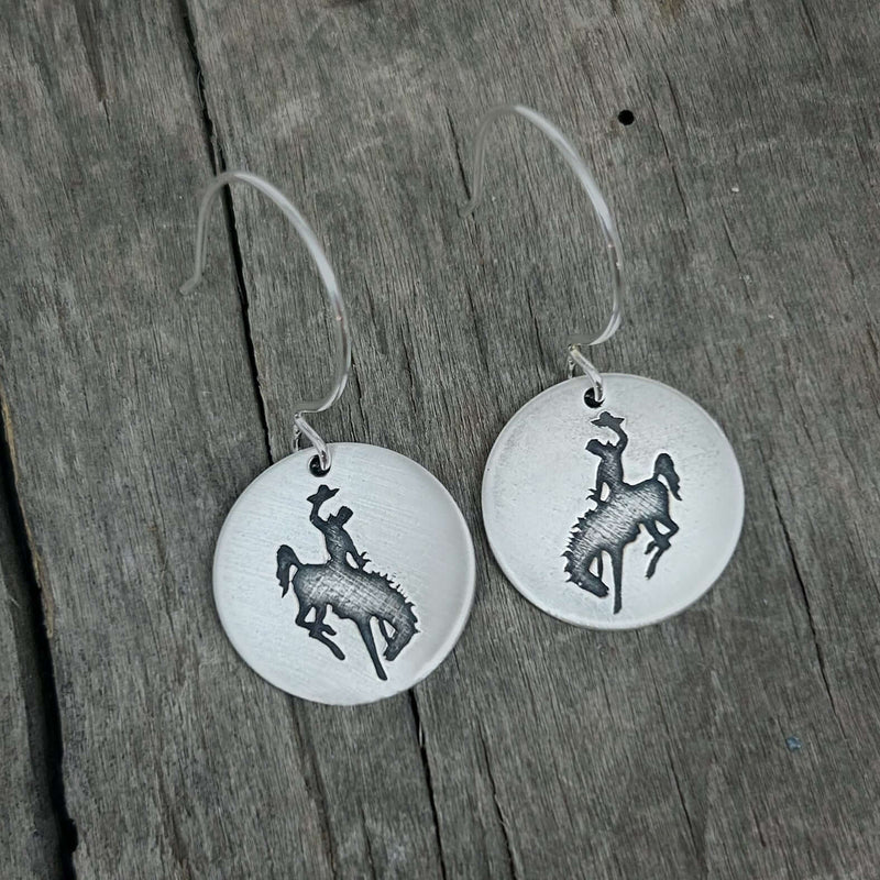 Steamboat Earrings featuring a bucking bronco silhouette on silver disks, perfect for cowgirl or cowboy styling.