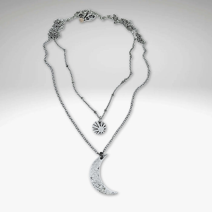 Sun and Moon Long Layered Necklace featuring a hammered crescent moon and small sun in matte silver finish.