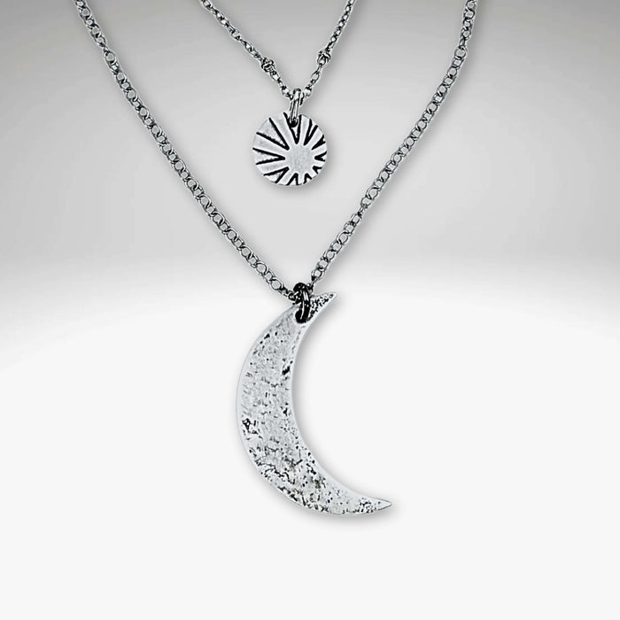 Sun and Moon Long Layered Necklace featuring a hammered crescent moon and sun charm in matte silver.