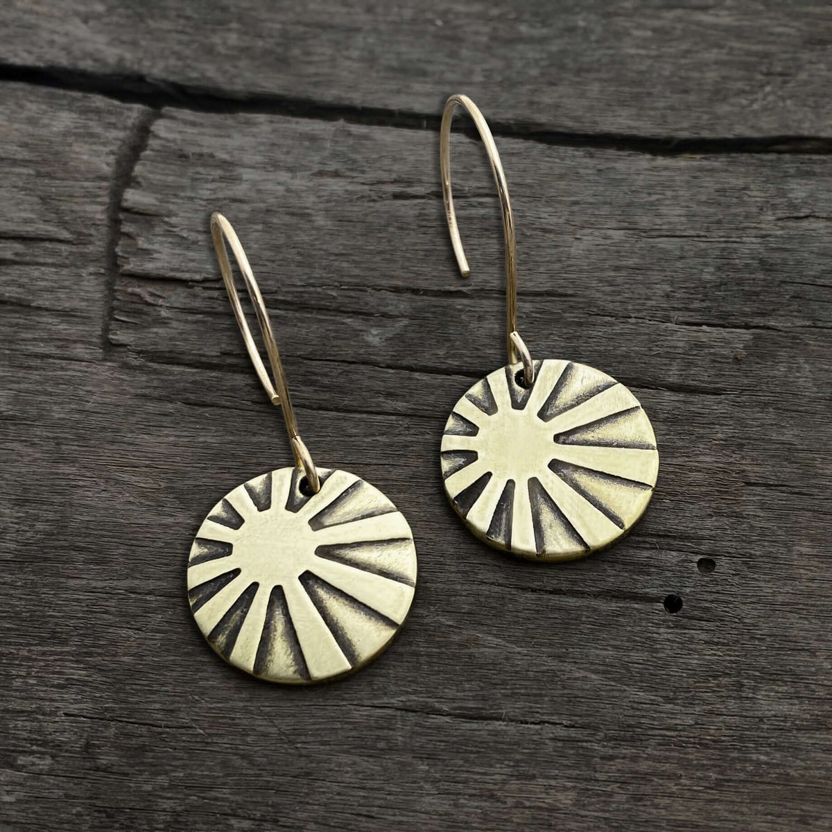Sunrays Earrings in antique brass, featuring round discs with sunray design on simple earwires.