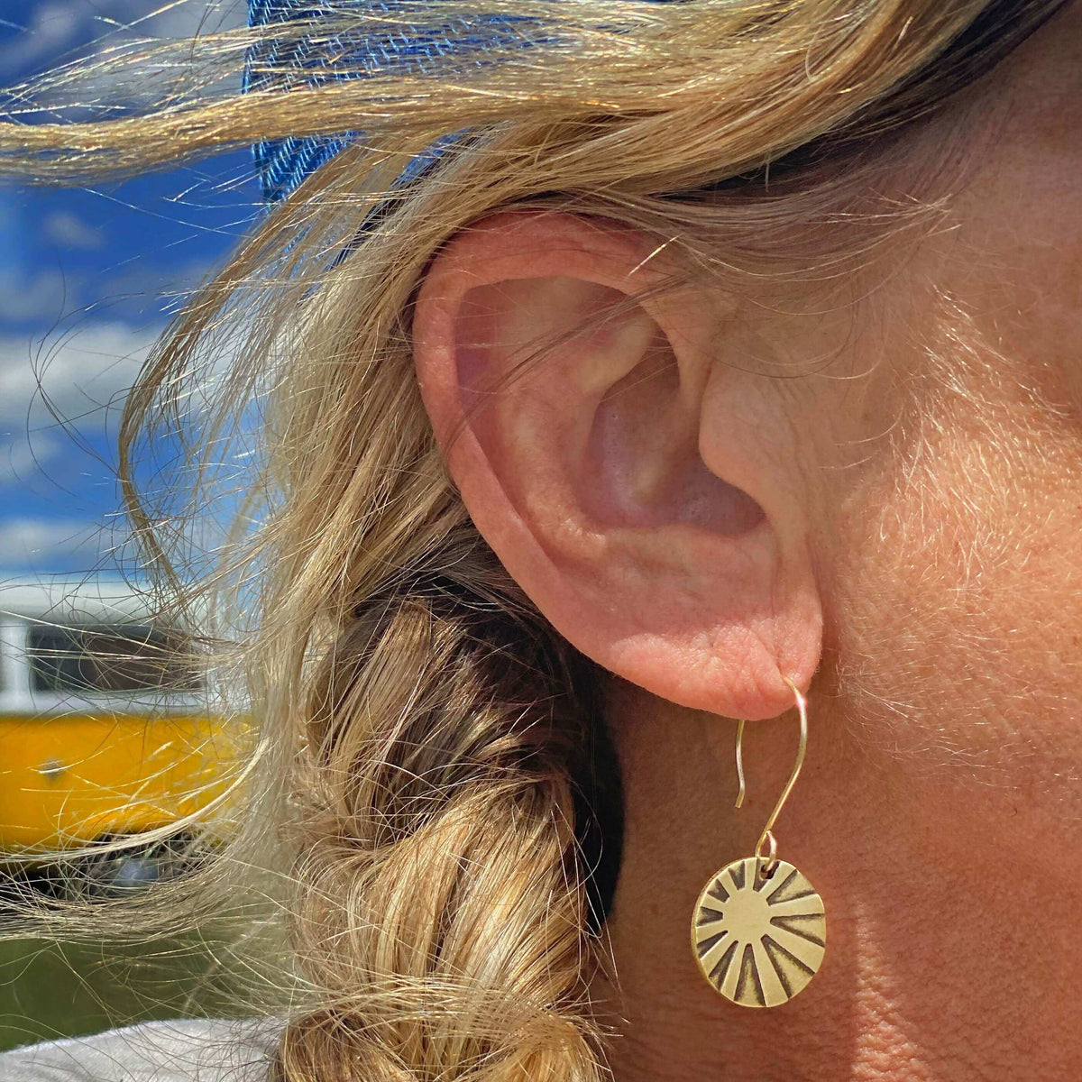 Mini Sun Ray Hoop Earrings worn by a woman, showcasing their stylish design and etched sun ray detailing.