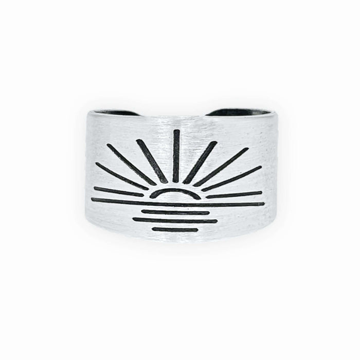 Sunrise Adjustable Ring in matte silver with sunburst design, handmade, adjustable, width 0.5 inches.