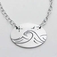 Swell Necklace features wave etching on matte silver pendant with an adjustable cable chain.