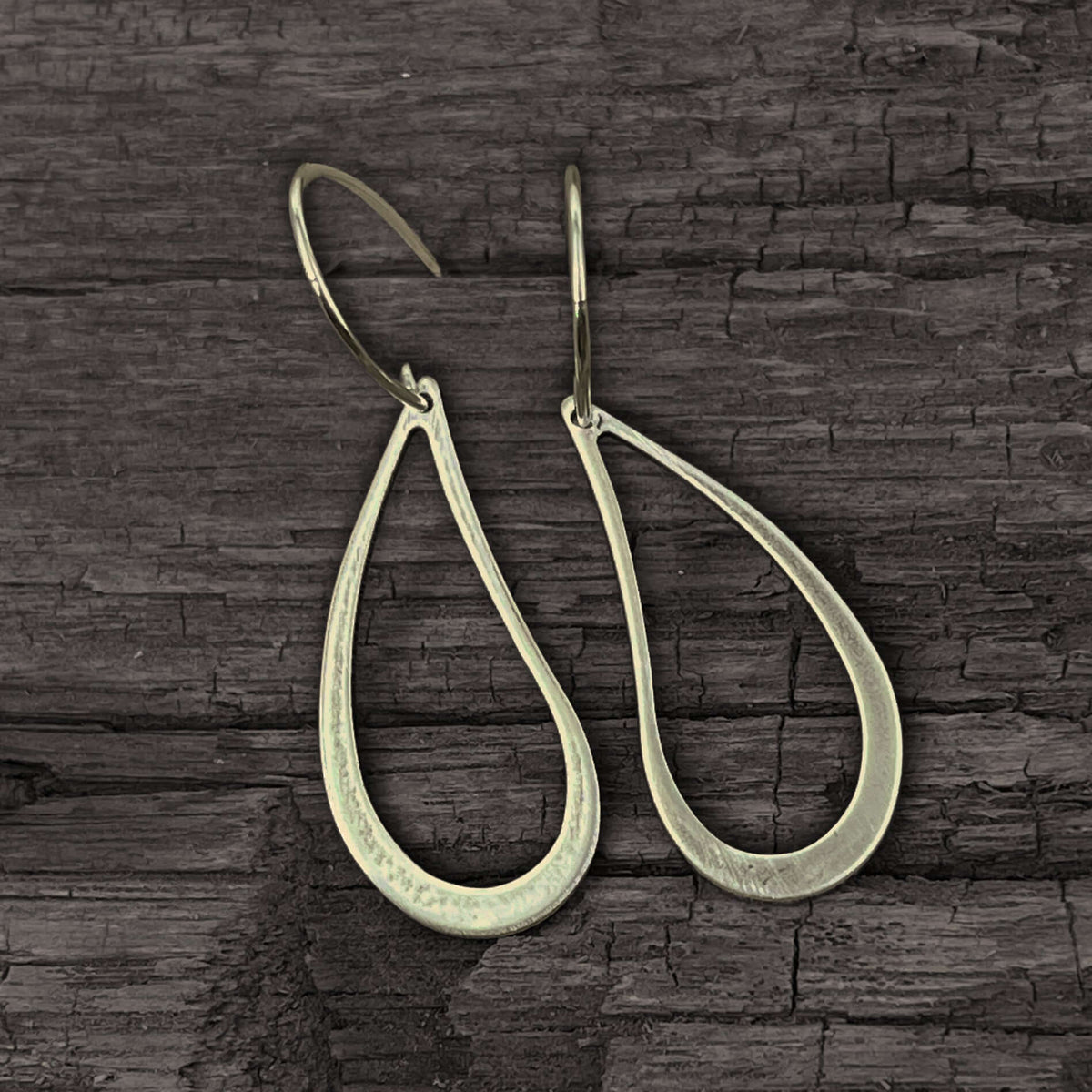 Teardrop Earrings made of solid brass with a hand hammered finish, showcasing an asymmetrical teardrop shape.