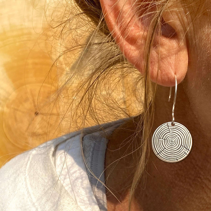 Timber Earrings- Tree Rings showcasing a delicate etched design on a model's ear, highlighting nature-inspired jewelry.