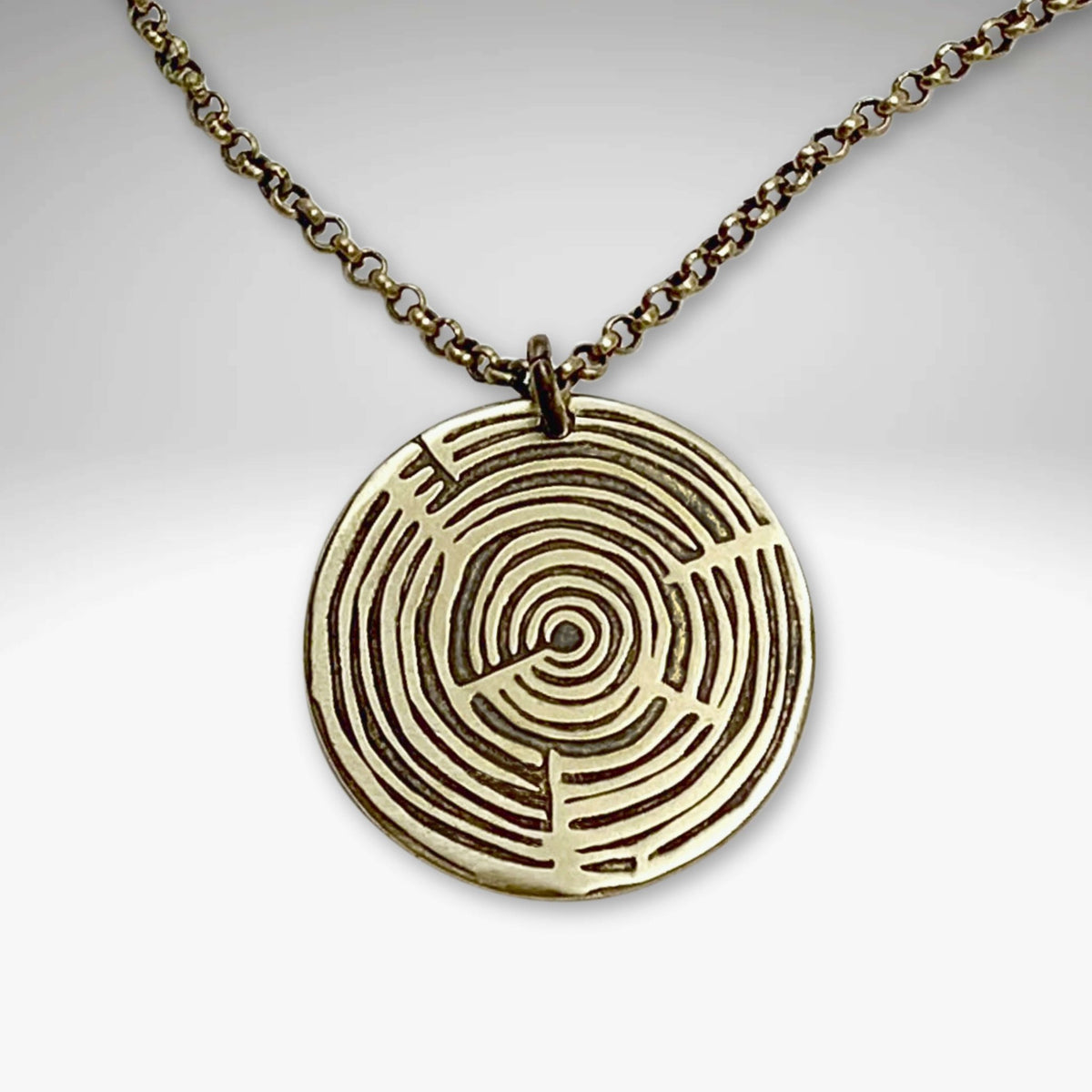 Timber Necklace featuring a round pendant with concentric circles on an adjustable chain.