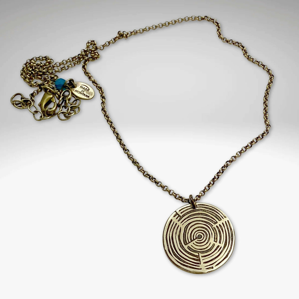 Timber Necklace featuring a circular pendant with concentric circle design on an adjustable chain, ideal for nature lovers.