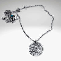 Timber Necklace featuring a circular pendant with a maze design on a stylish metal chain.