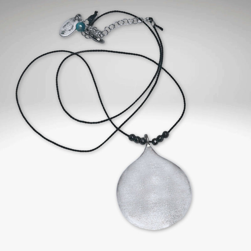 Waterdrop Necklace featuring a hammered pendant on a delicate silk cord with hematite beads.