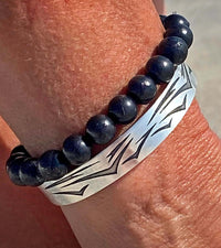Waves Cuff Bracelet paired with a beaded bracelet on a wrist, showcasing the intricate wave design.