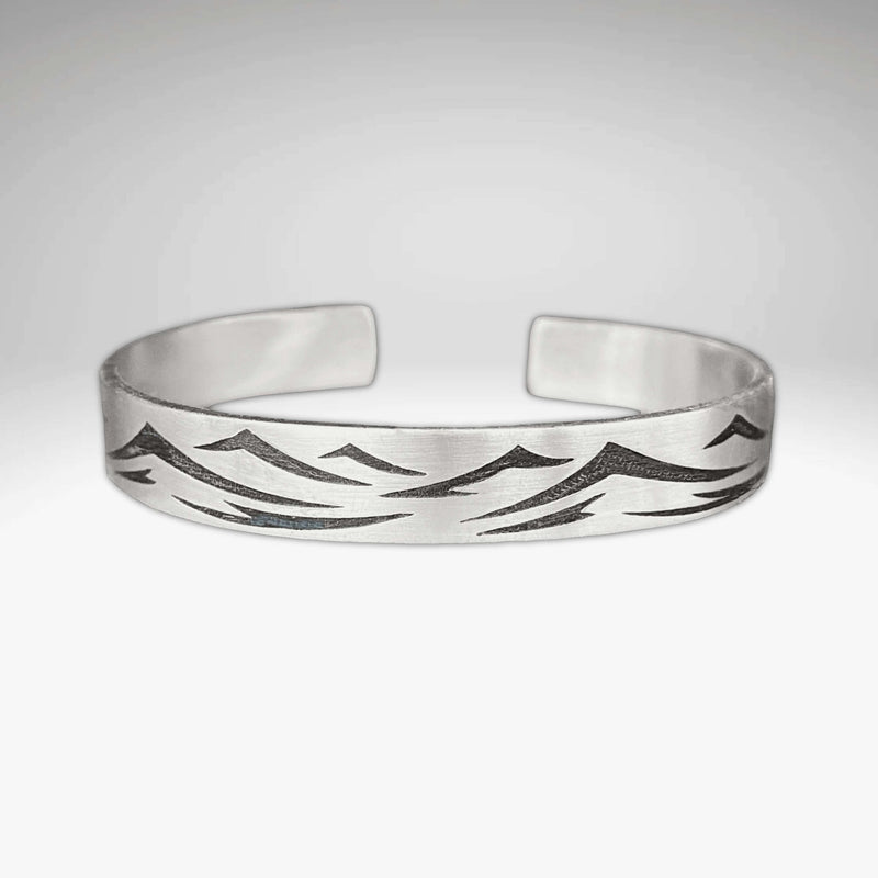 Waves Cuff Bracelet with wave pattern in matte silver finish, adjustable and suitable for all wrist sizes.