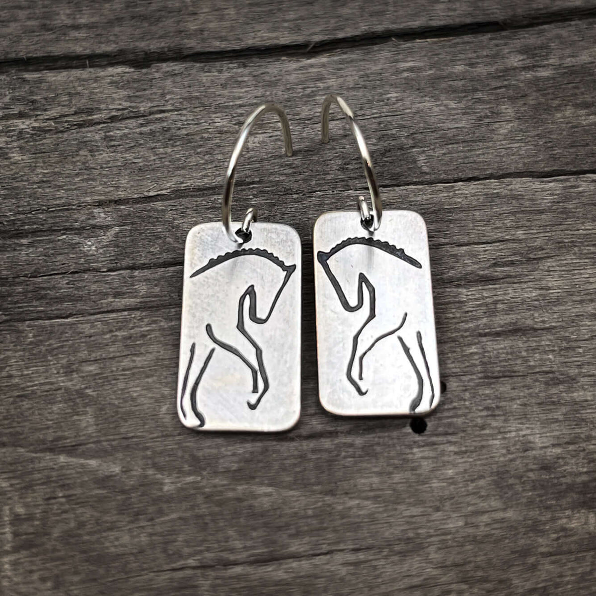 White Horse Dressage Earrings featuring etched silhouettes of powerful horses on brass.