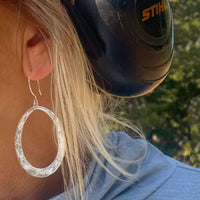 Wide Open Earrings worn by a woman, showcasing their elegant design and sterling silver finish.