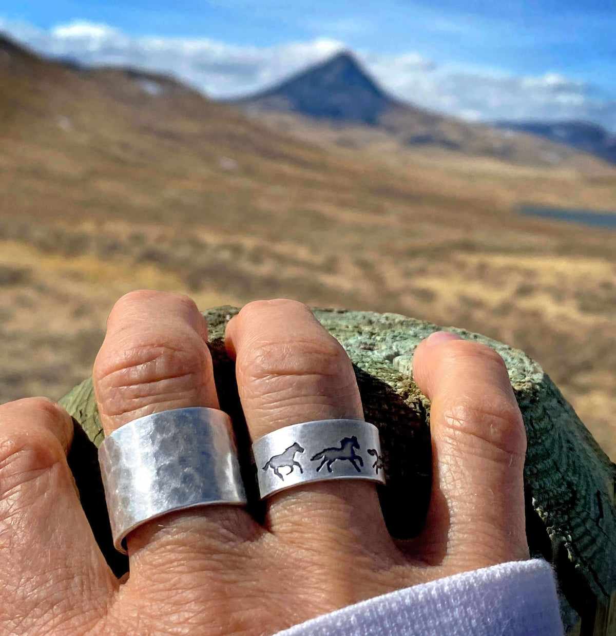 Wild Horses Adjustable Ring worn outdoors with mountains in the background, showcasing its design and craftsmanship.
