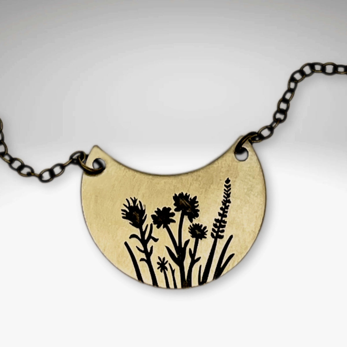 Wildflower Basket Necklace featuring intricate wildflower designs on a brass pendant.