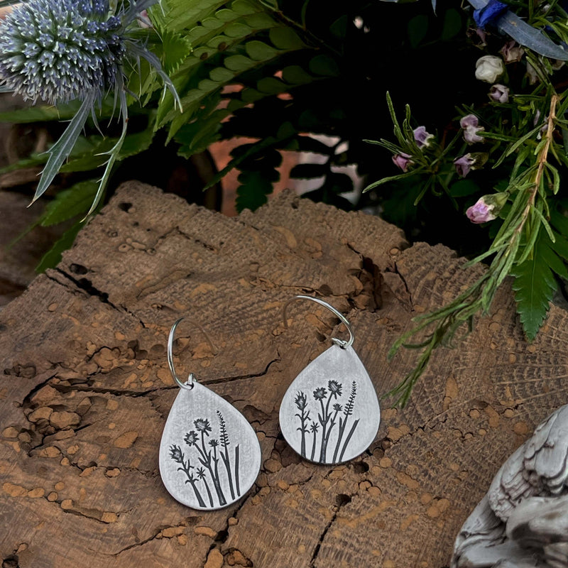 Wildflower Earrings featuring Indian Paintbrush and Wild Lupine on a wooden background with greenery.