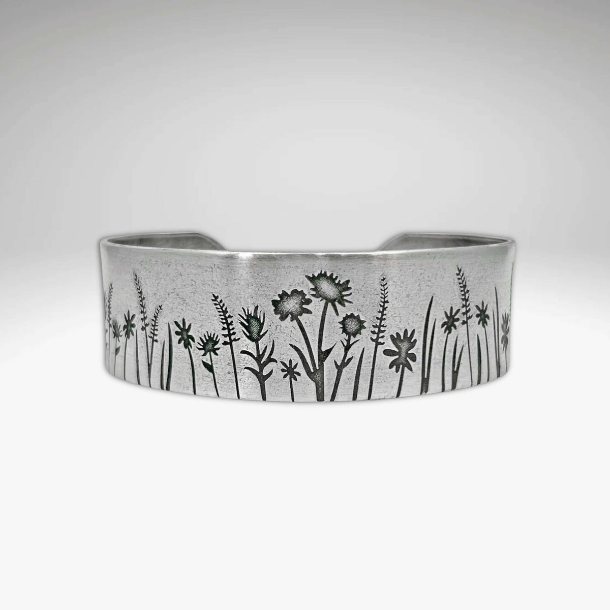 Wildflower Field Cuff featuring delicate wildflower designs on a silver bracelet for nature lovers.