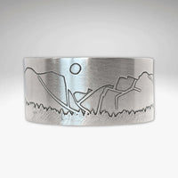 alt_tag: Yosemite Wide Cuff Bracelet- featuring a detailed landscape engraving with sun and mountains.