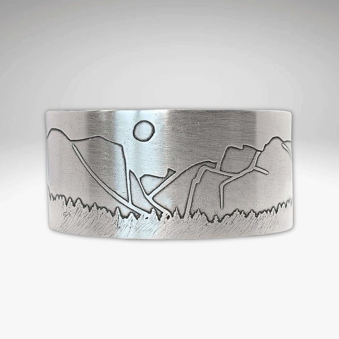 alt_tag: Yosemite Wide Cuff Bracelet- featuring a detailed landscape engraving with sun and mountains.