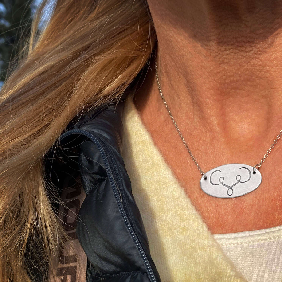 Close-up of the Ancient Buff Necklace worn on a person, showcasing its unique design and adjustable chain.