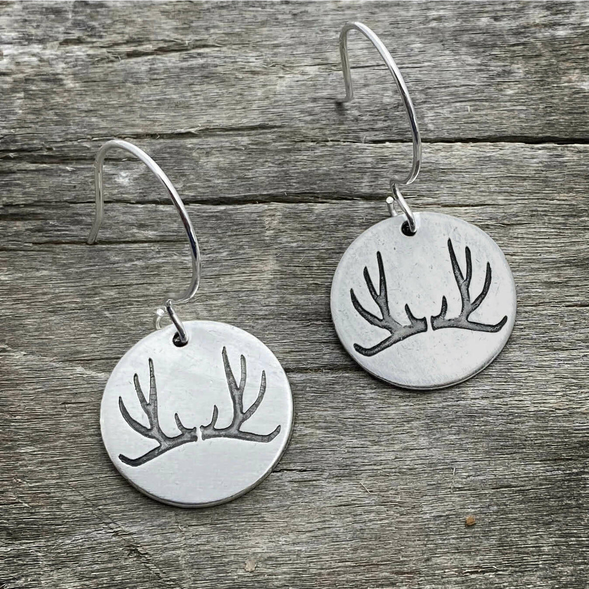 Antler Earrings made from etched brass discs featuring a nature-inspired antler design and sterling silver earwires.