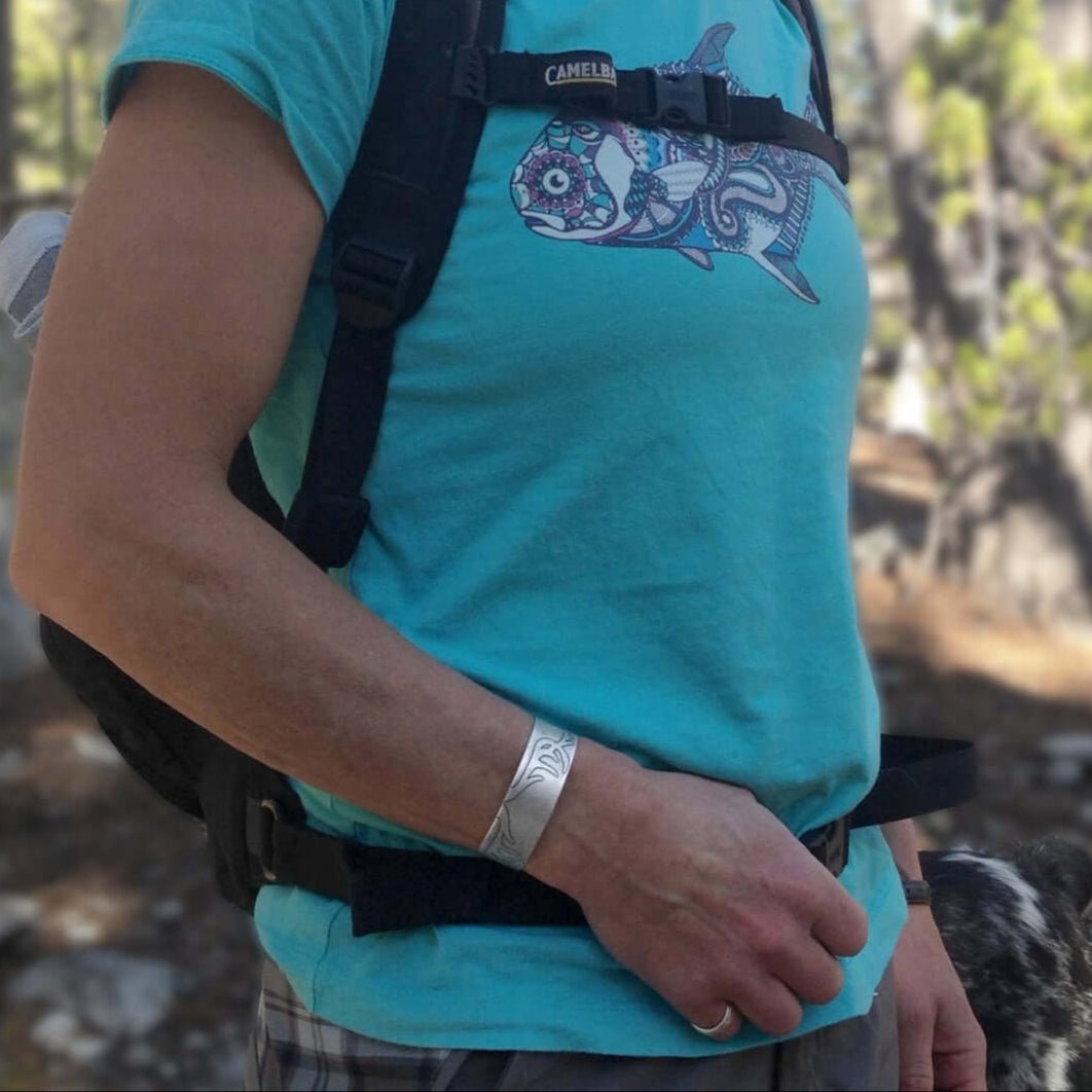 Antlers Cuff Bracelet worn by a hiker in a blue shirt, showcasing a unique hunting-themed design on an outdoor adventure.