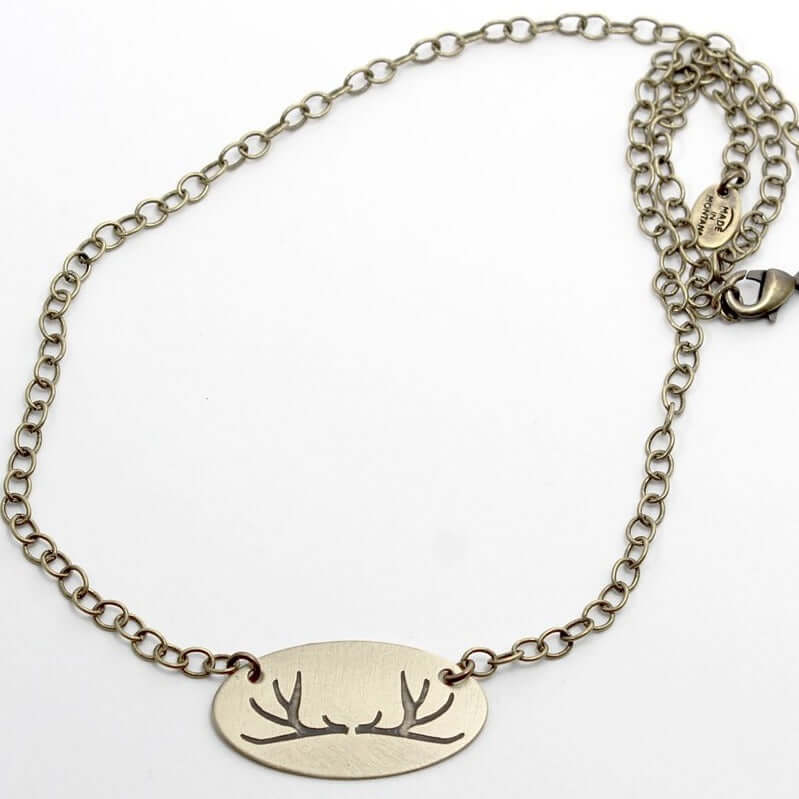 Antlers Necklace featuring an elegant oval pendant with etched antlers on a thin chain, ideal for nature lovers.