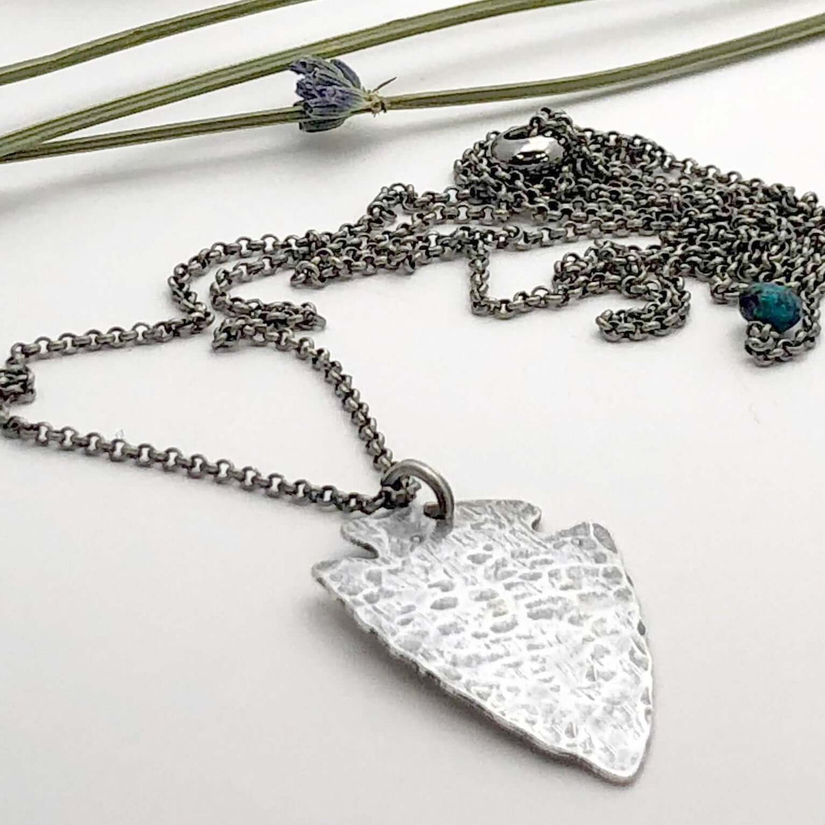Arrowhead Long Layered Necklace featuring a hammered silver pendant on a silver chain.