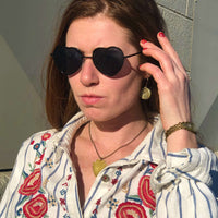 Model wearing Arrowhead Long Layered Necklace with heart-shaped sunglasses and embroidered shirt.
