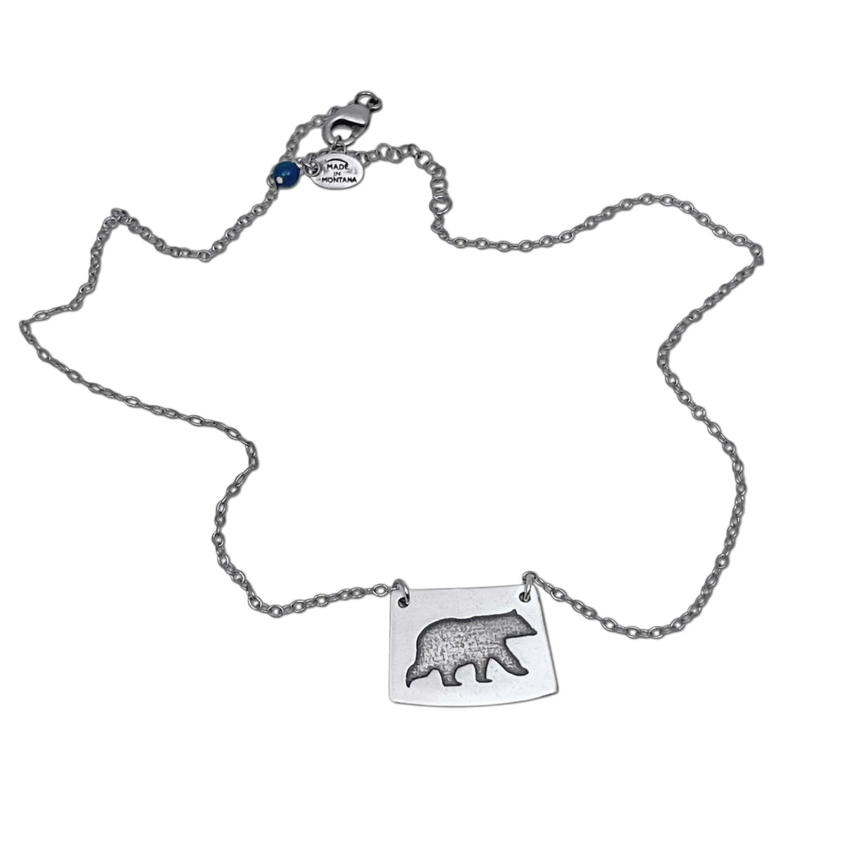Bear Boy Necklace featuring a black bear charm on an asymmetrical rectangle, displayed on a simple chain.