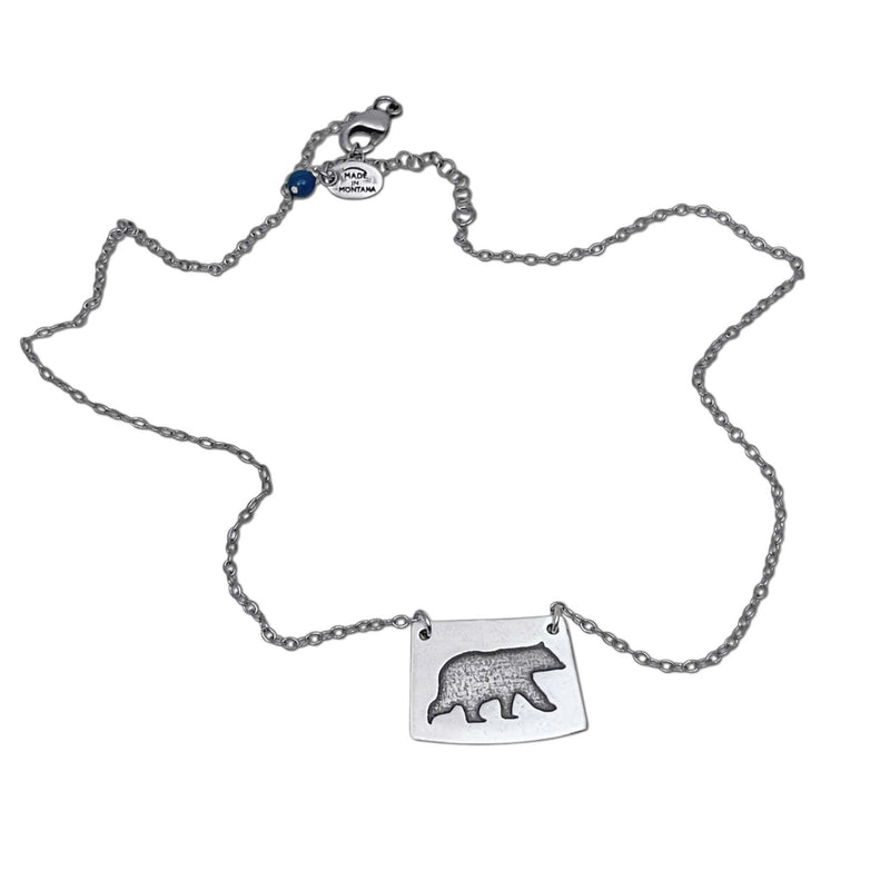 Bear Boy Necklace featuring a black bear charm on an asymmetrical rectangle, displayed on a simple chain.