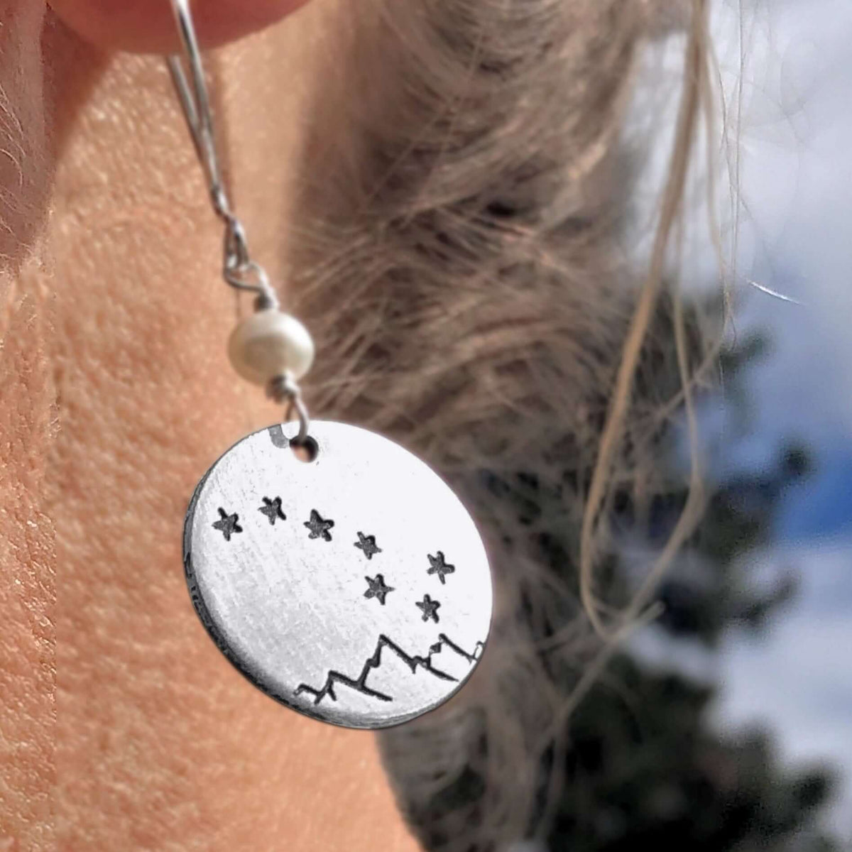 Big Dipper Earrings featuring etched stars over mountains, hanging from sterling silver earwire with a freshwater pearl bead.