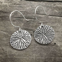 Stylish Blossom Earrings featuring a modern blossom design with a matte silver finish on a rustic wooden background.