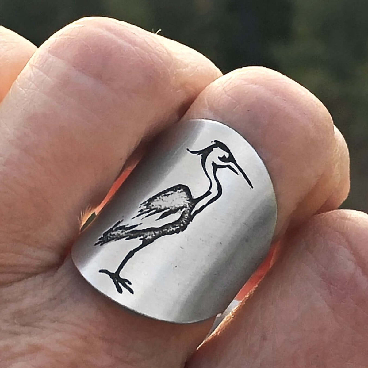 Blue Heron Adjustable Ring worn on a finger, featuring an etched majestic heron design.