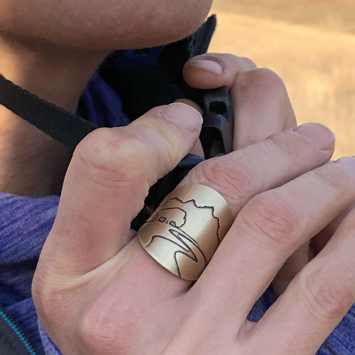 Buff in the Tetons Adjustable Ring worn on a hand, showcasing the intricate design inspired by the Grand Tetons.