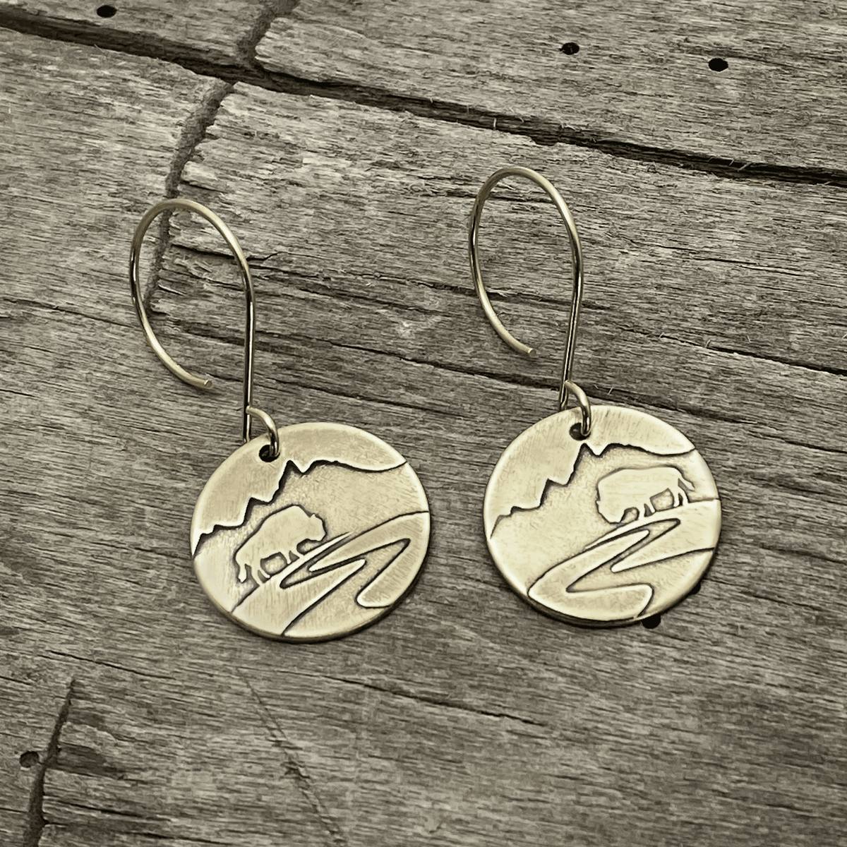 Buffalo in the Tetons Earring featuring etched buffalo and mountains on solid brass with a reflective design.