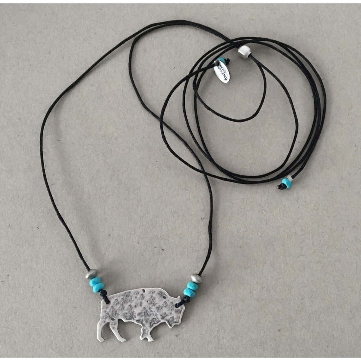Buffalo Necklace featuring a rustic buffalo pendant and adjustable cord with blue beads.