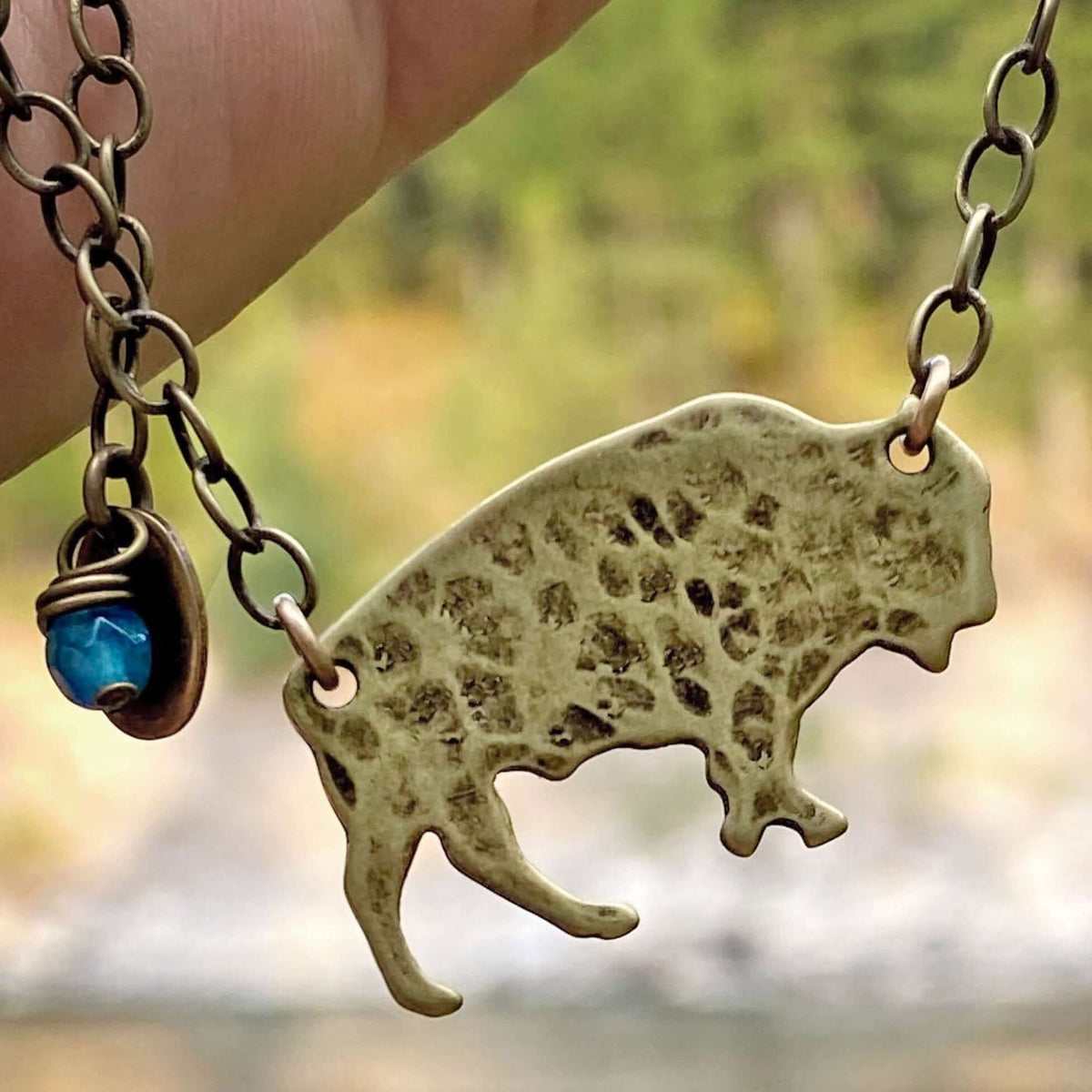 Buffalo Necklace featuring matte antique brass finish on an adjustable chain with a decorative bead.