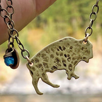 Buffalo Necklace featuring matte antique brass finish on an adjustable chain with a decorative bead.
