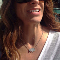 Woman wearing a Buffalo Necklace with a silver buffalo pendant, showcasing its rustic wild look.
