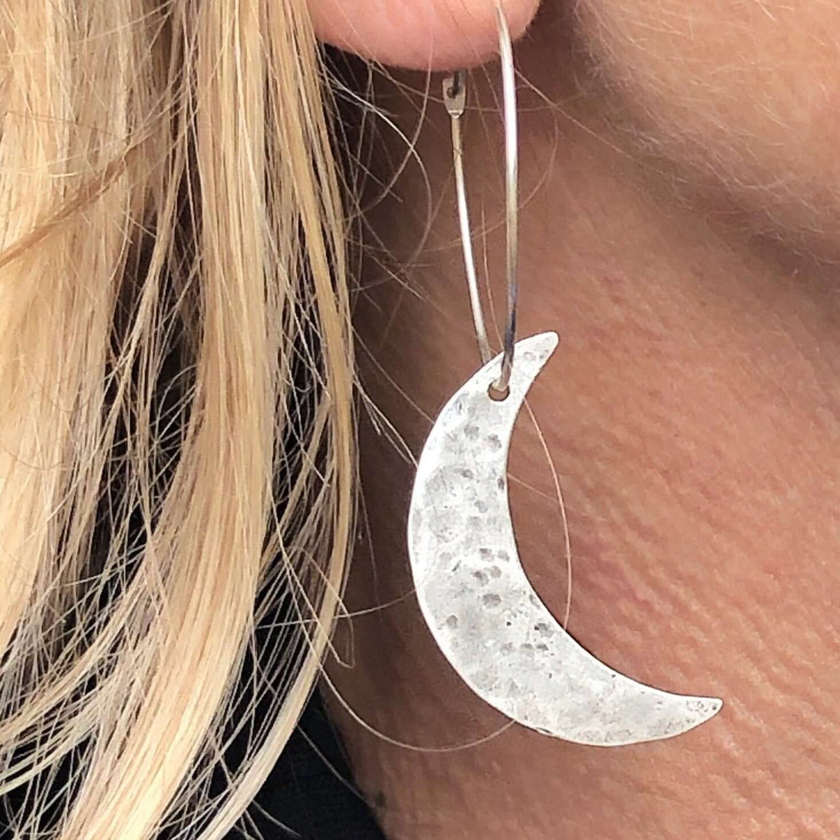 Crescent Moon Hoop Earrings featuring a hammered crescent moon design in sterling silver, hanging elegantly from a hoop.