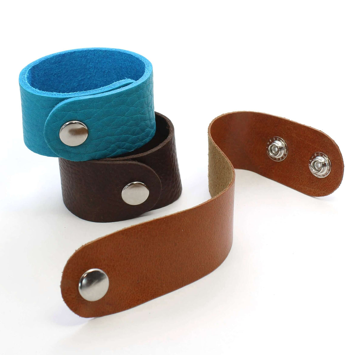 Echo Leather Cuff Bracelet collection showcasing blue, brown, and tan leather styles with snap closures.