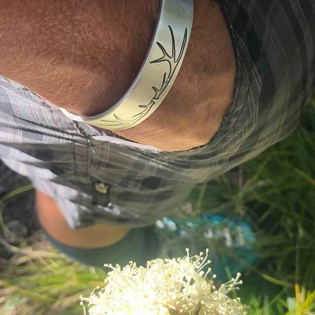 Elk Antlers Cuff Bracelet showcased on an individual's wrist, featuring subtle elk antler etching in matte silver finish.