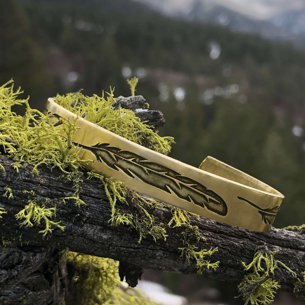 Feather Cuff Bracelet showcasing a feather design in antique brass, perfect for nature lovers and outdoor activities.