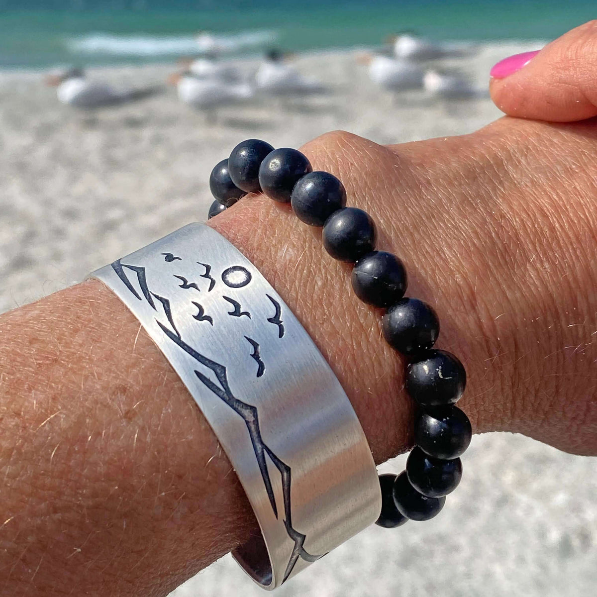 Fly Over 2 Bracelet worn on a wrist, featuring an adjustable cuff with beach-inspired design.
