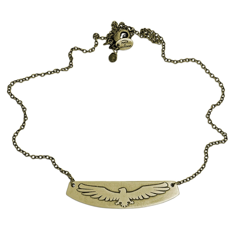 Freebird Necklace featuring an etched eagle design on a brass pendant with an adjustable cable chain.
